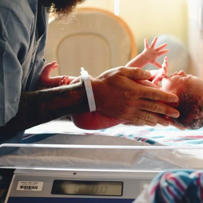 A newborn baby being cared for by a health professional